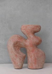 An abstract sculptural ceramic vase with a textured terracotta finish