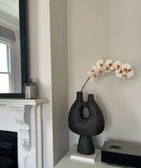 A modern black textured ceramic vase with a double neck and central hole