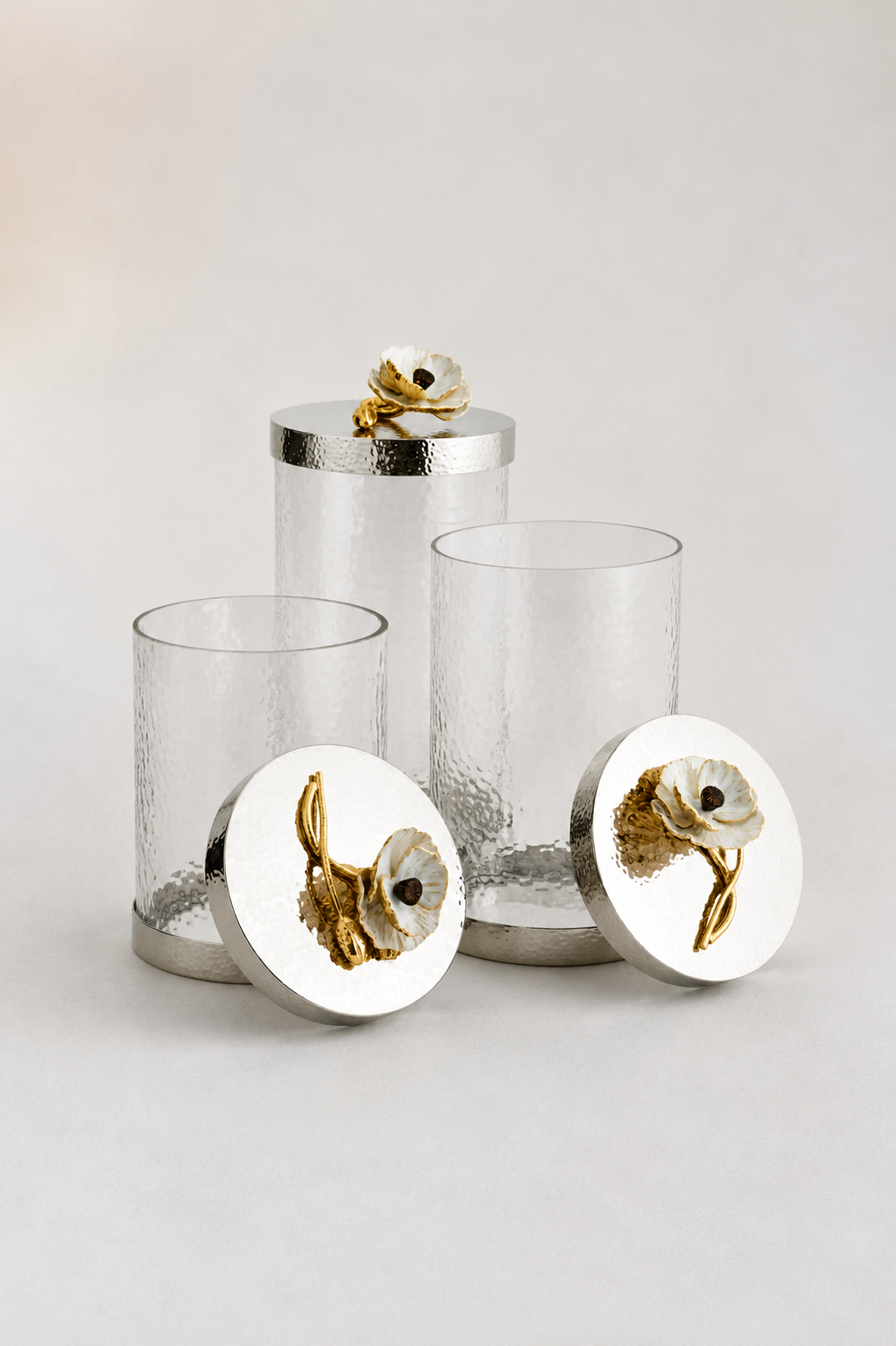 glass tumblers or canisters with silver-toned steel bases and floral lids