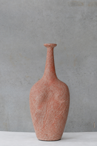 A textured terracotta fiber cement vase with a narrow neck and bulbous body